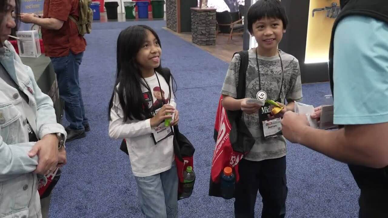 Massive crowd of 70,000 NRA attendees filling the Houston convention center halls, waving American flags and examining firearms exhibits.